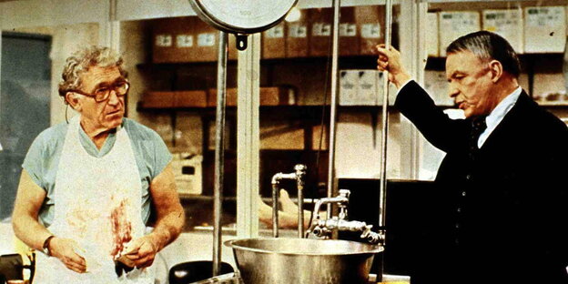 Frank Sinatra (r) steht in einer Küche, im gegenüber ein Mann mit blutverschmierter Schürze Frank Sinatra (r) steht in einer Küche, im gegenüber ein Mann mit blutverschmierter Schürze