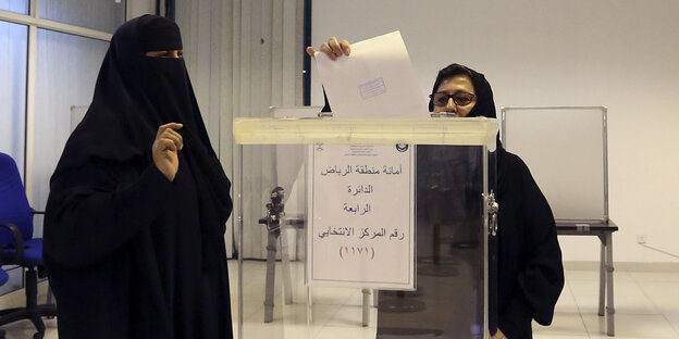 Zwei Frauen, eine davon verschleiert, bei der Stimmabgabe der Kommunalwahl in Saudi-Arabien Zwei Frauen, eine davon verschleiert, bei der Stimmabgabe der Kommunalwahl in Saudi-Arabien