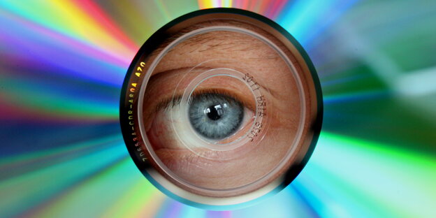 Auge guckt durch dass Loch einer CD Auge guckt durch dass Loch einer CD