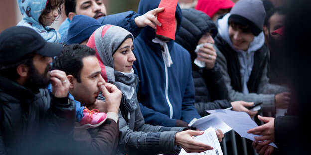 Geflüchtete stehen am Lageso in Berlin, wo sie sich registrieren lassen oder erste Unterstützungsleistungen erhalten Geflüchtete stehen am Lageso in Berlin, wo sie sich registrieren lassen oder erste Unterstützungsleistungen erhalten