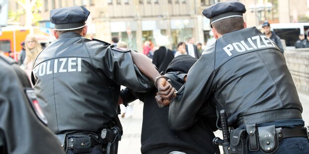 Polizisten führen einen Mann ab Polizisten führen einen Mann ab
