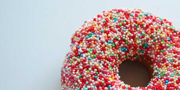 Ein Donut mit bunten Streuseln Ein Donut mit bunten Streuseln