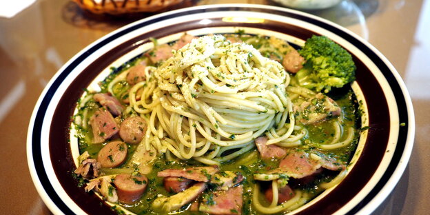 Ein Teller Spaghetti mit Würstel und Brokkoli Ein Teller Spaghetti mit Würstel und Brokkoli