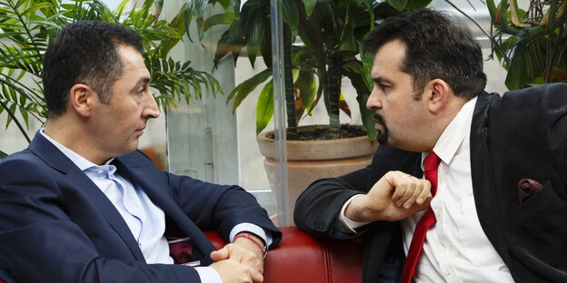 Der Grünen-Vorsitzende Cem Özdemir und Aiman Mazyek, Vorsitzender des Zentralrats der Muslime sitzen zusammen auf einem roten Sofa. Özdemir gestikuliert, Mazyek verzieht das Gesicht Der Grünen-Vorsitzende Cem Özdemir und Aiman Mazyek, Vorsitzender des Zentralrats der Muslime sitzen zusammen auf einem roten Sofa. Özdemir gestikuliert, Mazyek verzieht das Gesicht