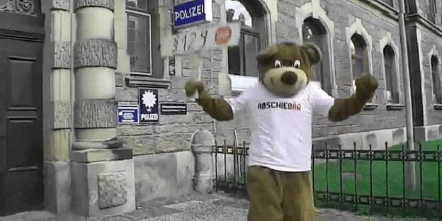 Ein Mann in einem rassistischen Bärenkostüm vor einer Polizeidienststelle Ein Mann in einem rassistischen Bärenkostüm vor einer Polizeidienststelle