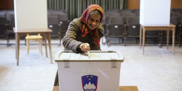 Eine ältere Frau an einer Wahlurne in Slowenien Eine ältere Frau an einer Wahlurne in Slowenien