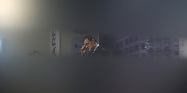 Ein Mann in Anzug rückt sich die Brille zurecht, es ist der spanische Minsterpräsident Rajoy Ein Mann in Anzug rückt sich die Brille zurecht, es ist der spanische Minsterpräsident Rajoy