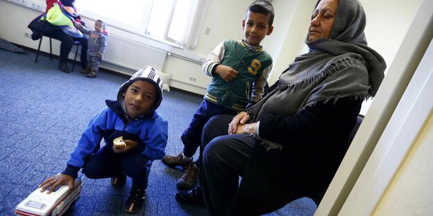 Eine geflüchtete Frau wartet mit ihren zwei Kinder in einer ehemaligen Einrichtung der US-Armee in Heidelberg Eine geflüchtete Frau wartet mit ihren zwei Kinder in einer ehemaligen Einrichtung der US-Armee in Heidelberg