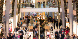 Viele Menschen in einem Shoppingcenter mit Weihnachtsbeleuchtung