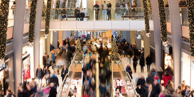 Viele Menschen in einem Shoppingcenter mit Weihnachtsbeleuchtung