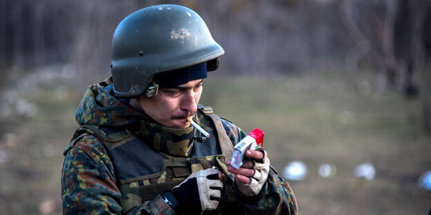 Ein ukrainischer Soldat steckt sich eine Zigarette an Ein ukrainischer Soldat steckt sich eine Zigarette an