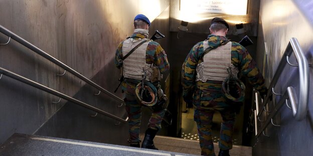 Zwei Soldaten steigen eine Treppe zu einer U-Bahn-Station in Brüssel herunter Zwei Soldaten steigen eine Treppe zu einer U-Bahn-Station in Brüssel herunter