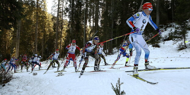 Biathletinnen an einem Anstieg Biathletinnen an einem Anstieg
