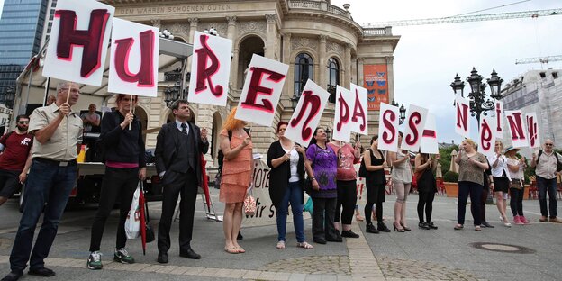 Demonstranten halten Schilder mit der Aufschrift "Hurenpass - Nein" hoch. Demonstranten halten Schilder mit der Aufschrift "Hurenpass - Nein" hoch.