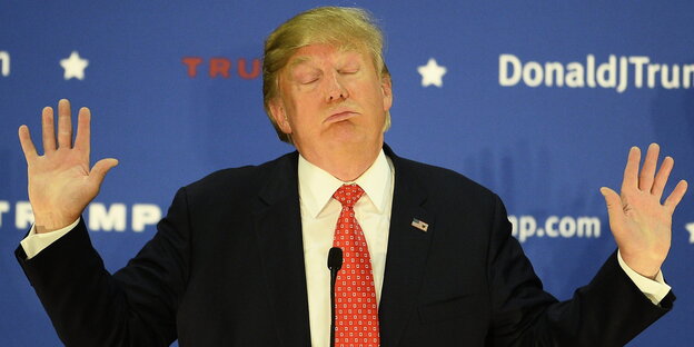 Donald Trump mit geschlossenen Augen und erhobenen Armen Donald Trump mit geschlossenen Augen und erhobenen Armen