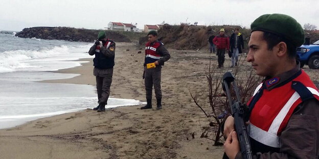 Drei Männer in Uniformen stehen am Strand Drei Männer in Uniformen stehen am Strand