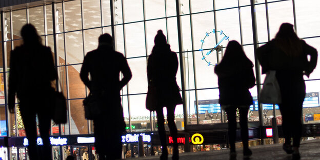 Passanten vor dem erleuchteten Hauptbahnhof in Köln. Passanten vor dem erleuchteten Hauptbahnhof in Köln.