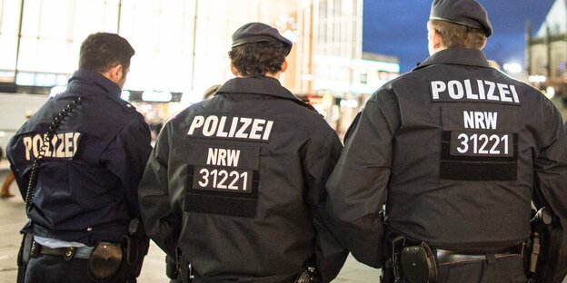 Polizisten in Uniform mit dem Rücken zur Kamera Polizisten in Uniform mit dem Rücken zur Kamera