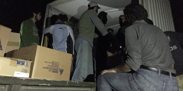 Männer packen Kartons in einen Lkw