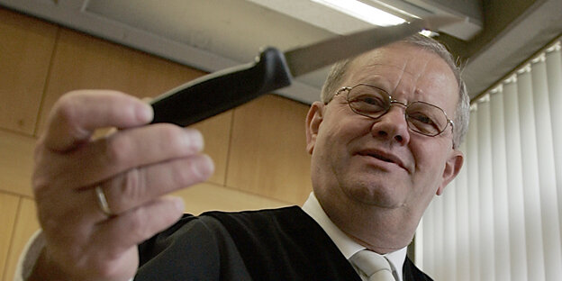 Ein Richter hält ein Messer in der Hand Ein Richter hält ein Messer in der Hand