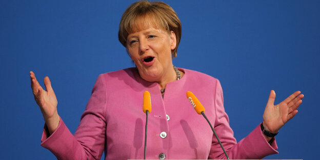 Angela Merkel macht ein überraschtes Gesicht während einer Podiumsrede Angela Merkel macht ein überraschtes Gesicht während einer Podiumsrede
