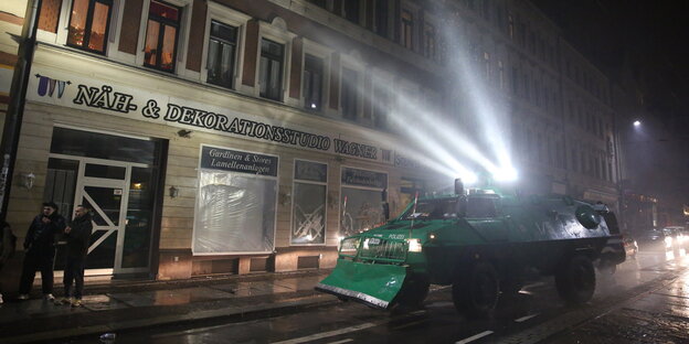 Ein Radpanzer der Polizei fährt durch den Stadtteil Connewitz