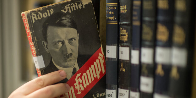 Eine Originalausgabe von "Mein Kampf" wird aus dem Regal gezogen Eine Originalausgabe von "Mein Kampf" wird aus dem Regal gezogen
