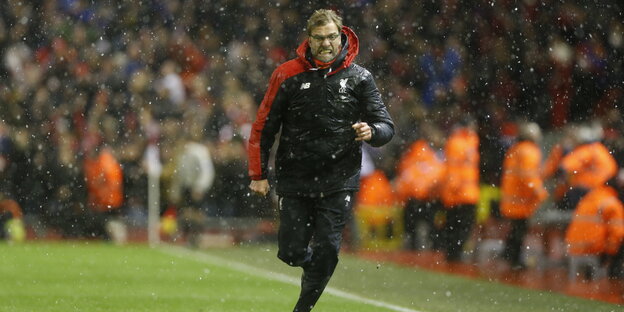 Liverpool-Trainer Jürgen Klopp rennt an der Seitenlinie durch Schneeregen Liverpool-Trainer Jürgen Klopp rennt an der Seitenlinie durch Schneeregen