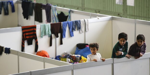 Kinder gucken über Trennwände in der Notunterkunft im Berliner Flughafen Tempelhof Kinder gucken über Trennwände in der Notunterkunft im Berliner Flughafen Tempelhof