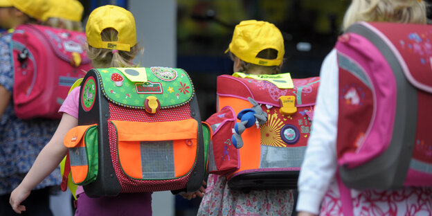 Kinder mit Schulranzen laufen Kinder mit Schulranzen laufen