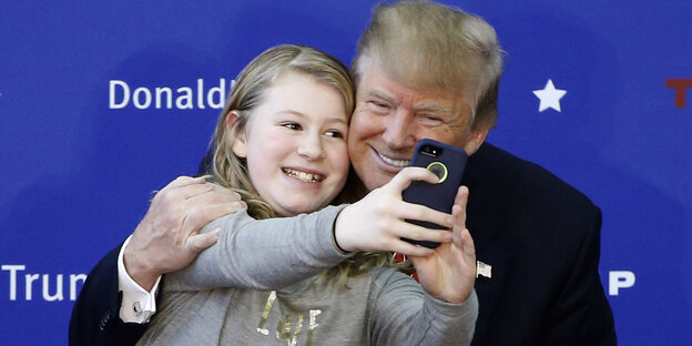 Donald Trump posiert mit einem jungen Fan, um ein Selfie zu machen. Donald Trump posiert mit einem jungen Fan, um ein Selfie zu machen.
