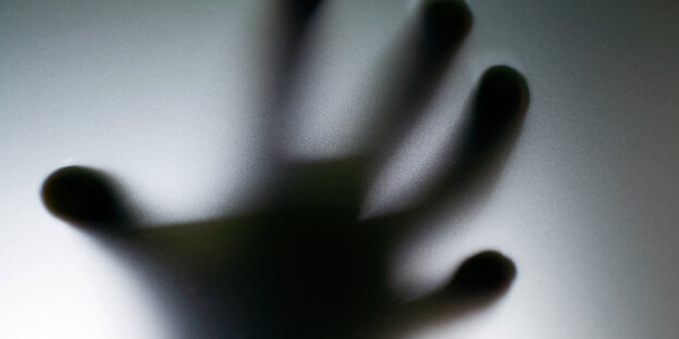 Hand hinter einer Milchglasscheibe im Gegenlicht Hand hinter einer Milchglasscheibe im Gegenlicht
