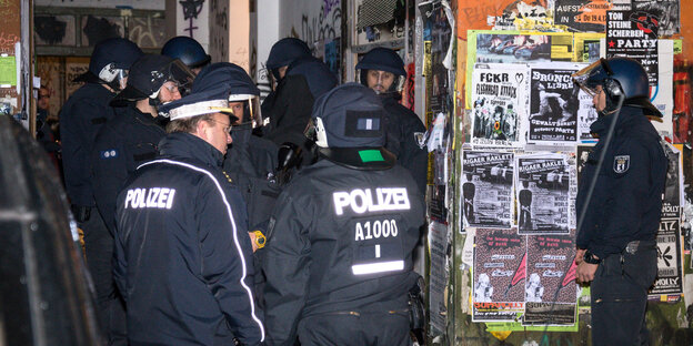 Polizisten stehen vor einem Hauseingang