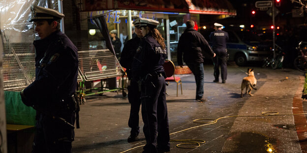 Polizisten stehen bei Nacht auf einer Straße Polizisten stehen bei Nacht auf einer Straße