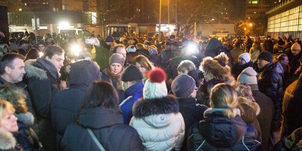 Menschen stehen im Dunkeln auf einer Demonstration. Menschen stehen im Dunkeln auf einer Demonstration.