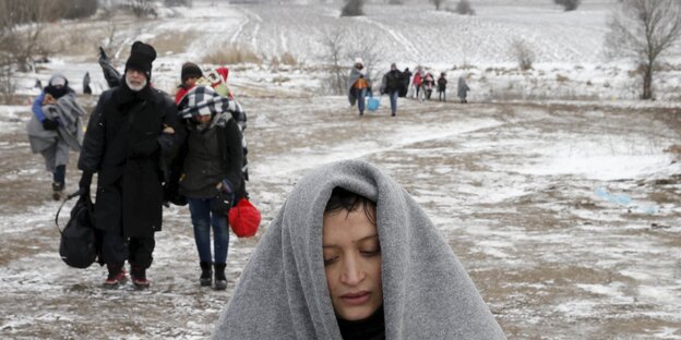 Verstreut gehende Menschen in einer verschneiten Landschaft Verstreut gehende Menschen in einer verschneiten Landschaft