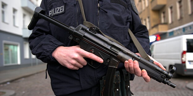 ein Polizist mit Maschinengewehr