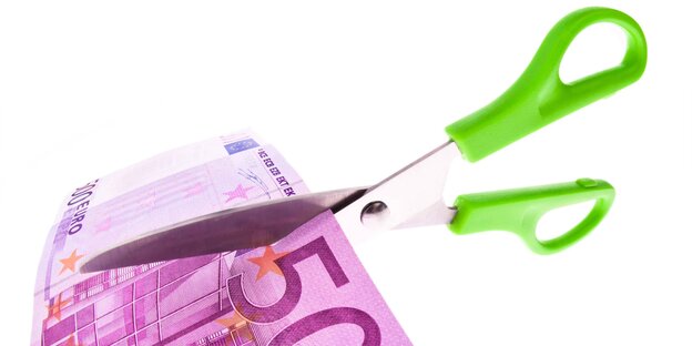 Papierschere mit grünem Griff schneidet 500-Euro-Schein durch. Papierschere mit grünem Griff schneidet 500-Euro-Schein durch.