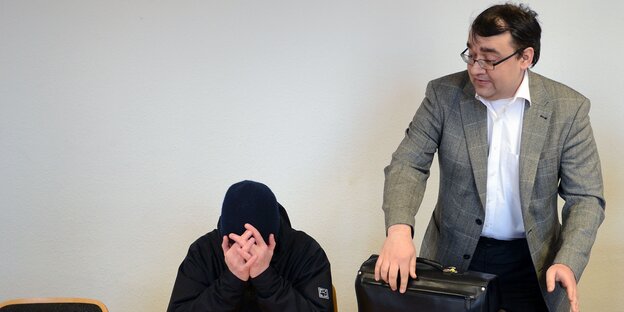 Anwalt Alexej Danckwardt, stehend, mit einem Mandanten, sitzend. Anwalt Alexej Danckwardt, stehend, mit einem Mandanten, sitzend.