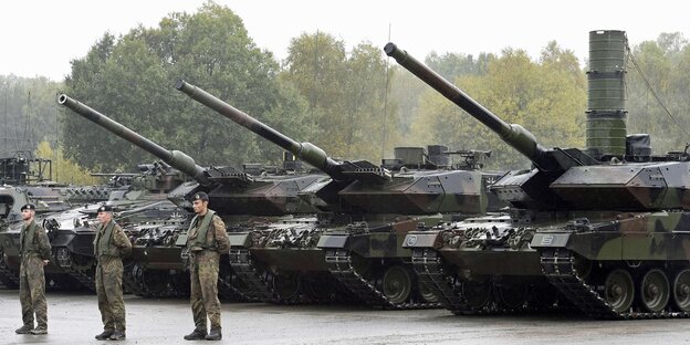 Bundeswehr-Soldaten stehen vor drei Panzern Bundeswehr-Soldaten stehen vor drei Panzern