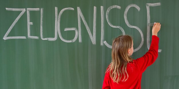 Ein Kind schreibt "Zeugnisse" an die Tafel