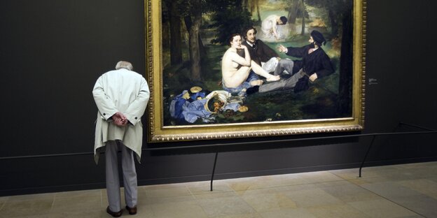 „Le déjeuner sur l’herbe“ im Museum, daneben ein Mann „Le déjeuner sur l’herbe“ im Museum, daneben ein Mann