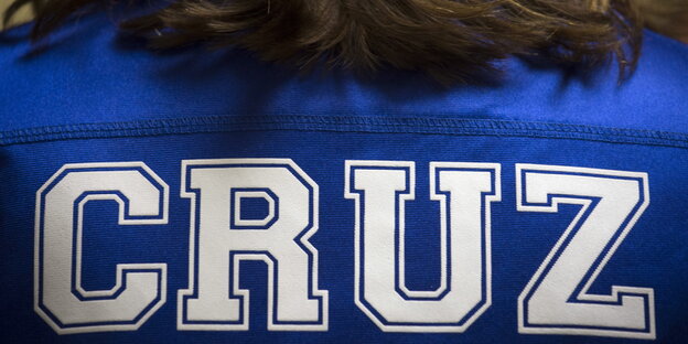 Der Rücken einer Frau. Sie trägt ein blaues Shirt, auf dem Cruz steht. Der Rücken einer Frau. Sie trägt ein blaues Shirt, auf dem Cruz steht.