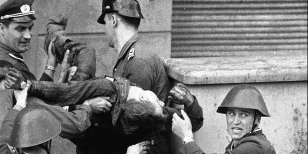 Angehörige der DDR-Grenztruppen tragen am 17. August 1962 Peter Fechter, der beim Fluchtversuch angeschossen wurde, über die Grenzanlagen in Berlin. Angehörige der DDR-Grenztruppen tragen am 17. August 1962 Peter Fechter, der beim Fluchtversuch angeschossen wurde, über die Grenzanlagen in Berlin.