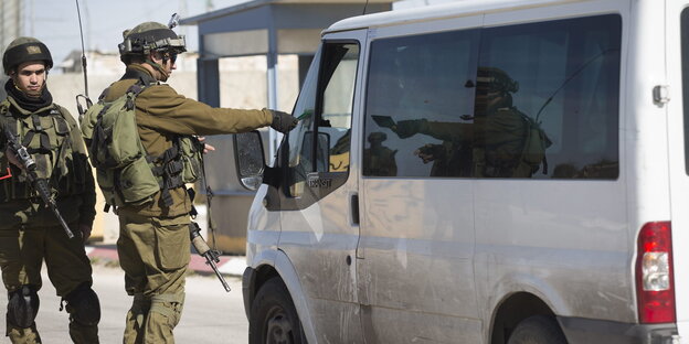 Israelische Soldaten lassen sich die Papiere eines Fahrzeugführers zeigen Israelische Soldaten lassen sich die Papiere eines Fahrzeugführers zeigen