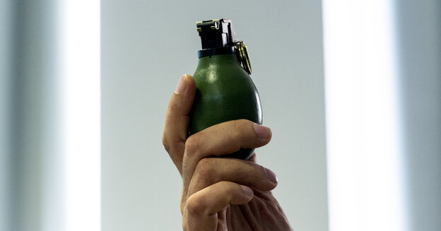 Hand eines Unbekannten hält Handgranate in die Höhe. Hand eines Unbekannten hält Handgranate in die Höhe.