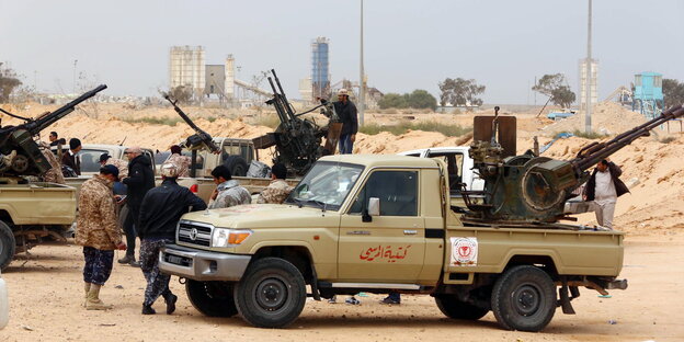 Mehrere Männer an Pick-up-Trucks mit schweren Waffen Mehrere Männer an Pick-up-Trucks mit schweren Waffen