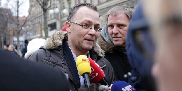 Ein Mann mit Brille und Anorak mit Fellkragen wird interviewt. Ein Mann mit Brille und Anorak mit Fellkragen wird interviewt.