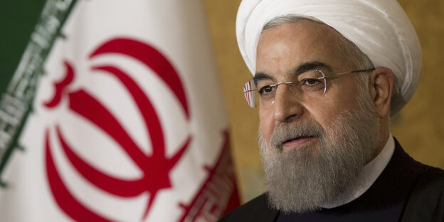 Hassan Rohani neben einer iranischen Fahne Hassan Rohani neben einer iranischen Fahne