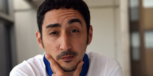 Eko Fresh zieht eine Augenbraue hoch und stützt sein Gesicht zwischen Daumen und Zeigefinger auf. Eko Fresh zieht eine Augenbraue hoch und stützt sein Gesicht zwischen Daumen und Zeigefinger auf.